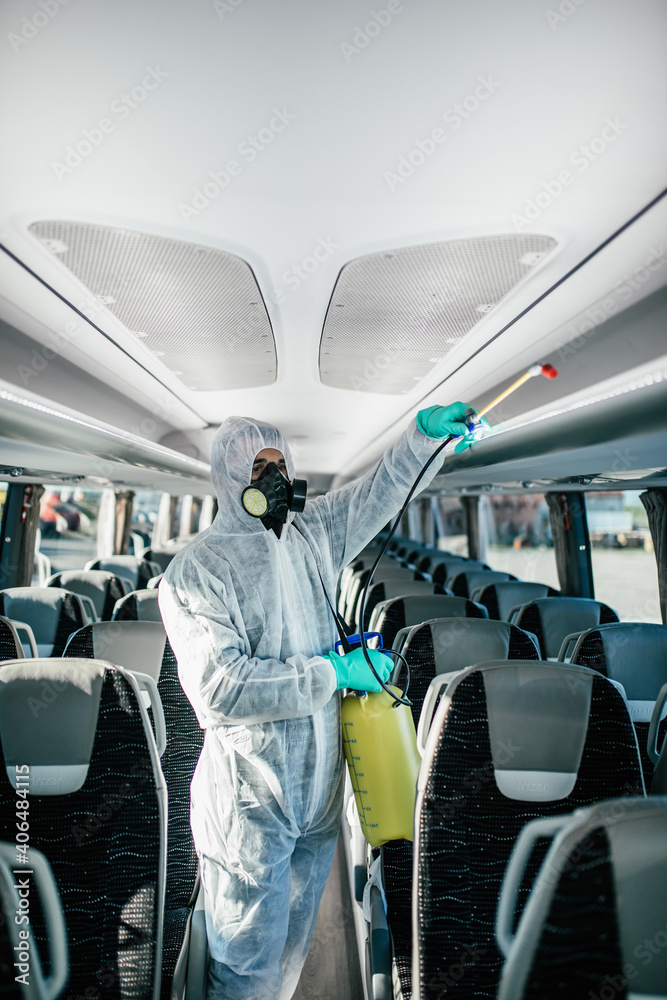 Professional chemical cleaning bus seats. Bus disinfection. Exterminator in workwear.