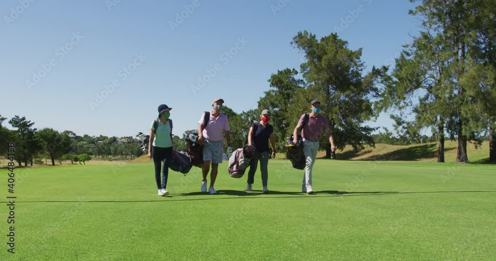 Senior people wearing face masks walking with their golf bags at golf course Senior people wearing face masks walking with their golf bags at golf course