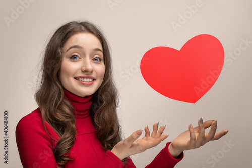 Girl with red cardboard heart, heart hanging in the air © Snizhana