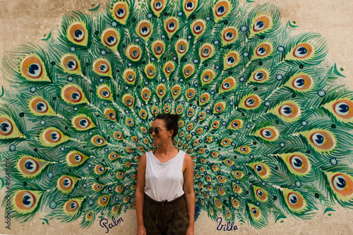 woman in front of a painting of a peacock in Mirissa, Sri Lanka