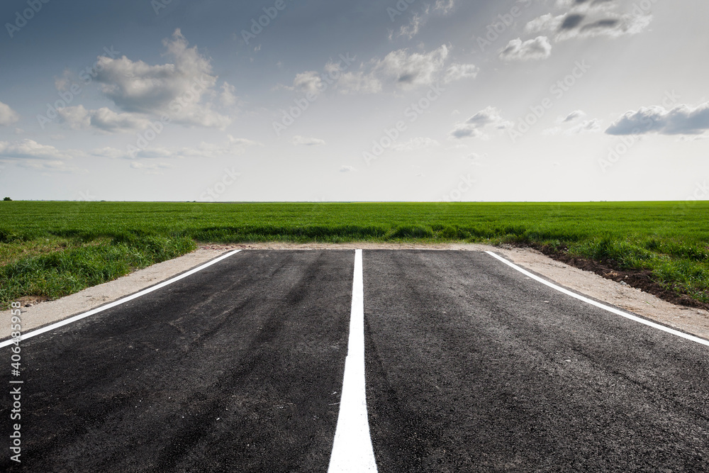 Dead end road in green field landscape