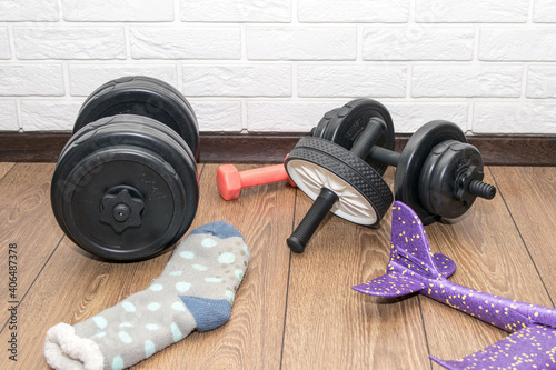 A home gym, dumbbells, and ab roller on the wooden floor