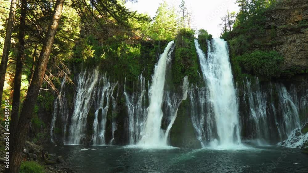Landscape view of Burney Falls, forest waterfall in California, with water falling down a cliff Landscape view of Burney Falls, forest waterfall in California, with water falling down a cliff
