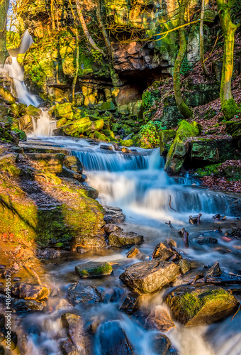 A long exposure view of water cascading over waterfalls at Lumsdale on Bentley Brook, Derbyshire, UK