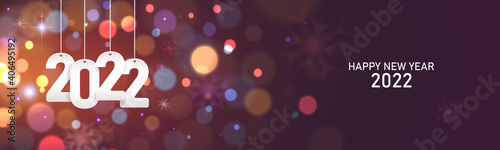 Happy new year 2022. Hanging white paper number on a horizontal defocused colorful blurry background.