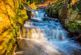 A long exposure view of water cascading over waterfall steps at Lumsdale on Bentley Brook, Derbyshire, UK