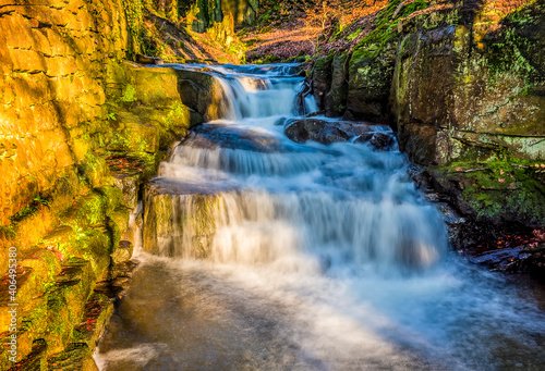 A long exposure view of water cascading over waterfall steps at Lumsdale on Bentley Brook  Derbyshire  UK