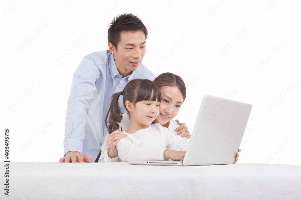Portrait of daughter playing laptop with parents 