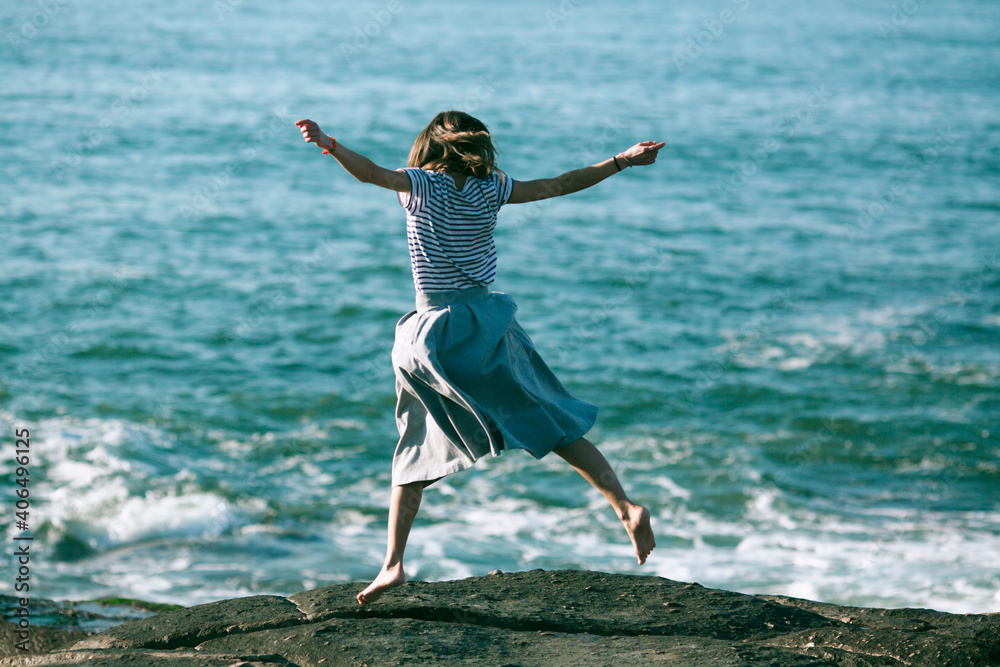 Obraz premium Young dance woman is engaged in choreography on the ocean coast.