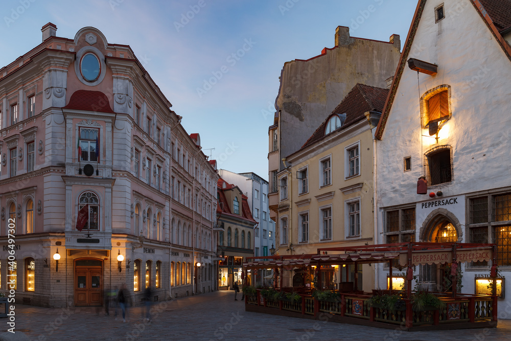 TALLINN, ESTONIA - JULY, 07, 2020: Old town street view with tourists. Summer sunset time