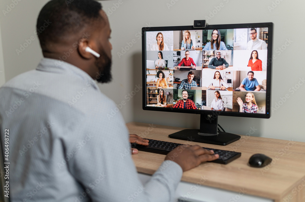 Successful male employee at online meeting with multiracial colleagues, discuss work projects. Business man on video conference, using laptop, talking with coworkers, communication concept