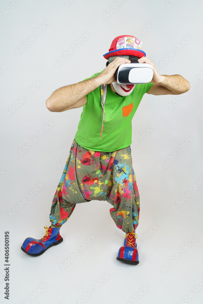 The clown is playing, he has virtual glasses on his head, looks like through binoculars. Isolated on white The clown is playing, he has virtual glasses on his head, looks like through binoculars. Isolated on white