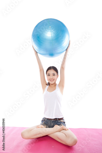 Portrait of a Young woman exercising with ball