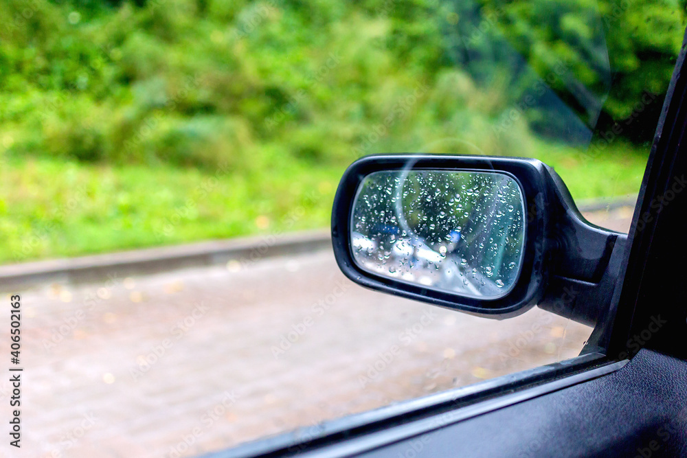 Black rearview mirror with raindrops.
