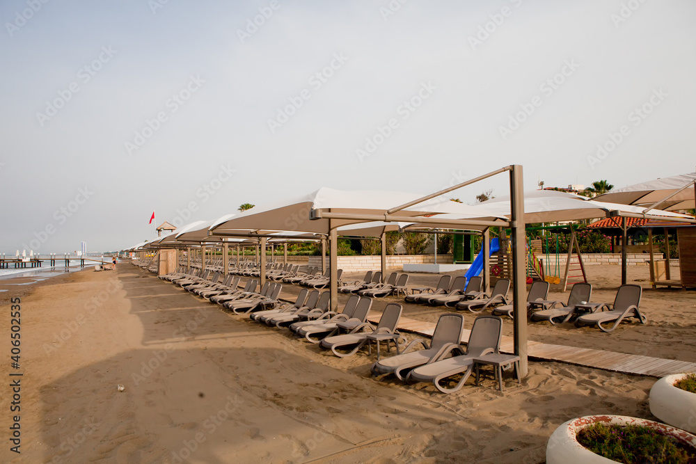 Beach near the sea with sun loungers and parasols