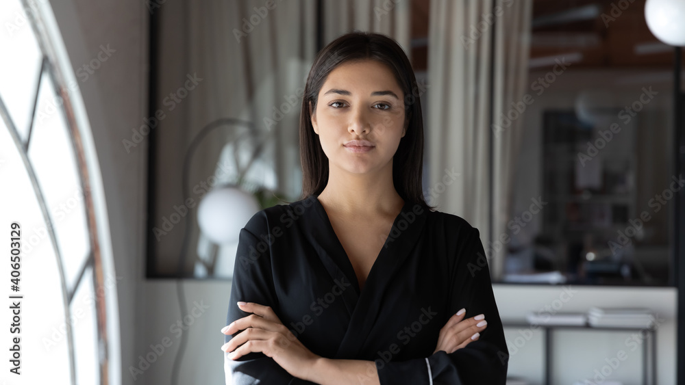 Head shot portrait confident Indian businesswoman hr manager standing in modern office with arms crossed, serious entrepreneur team leader mentor posing for corporate photo, looking at camera Head shot portrait confident Indian businesswoman hr manager standing in modern office with arms crossed, serious entrepreneur team leader mentor posing for corporate photo, looking at camera