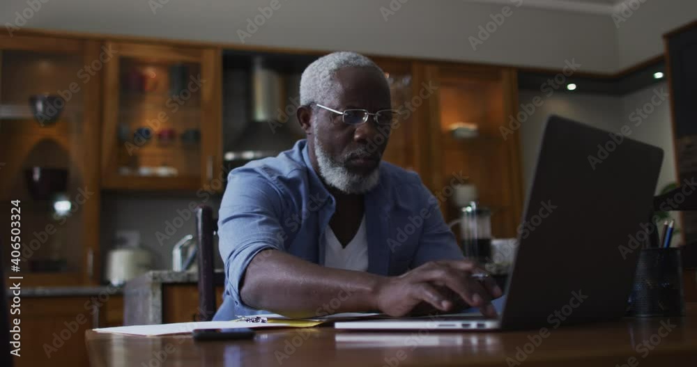 African american senior man using laptop and calculating finances at home African american senior man using laptop and calculating finances at home