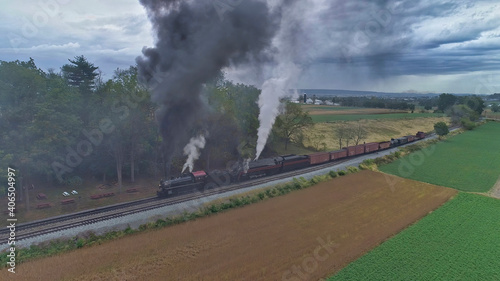 Aerial View of 2 Restored Antique Steam Engines and Double Heading and Steaming Up at a Small Rail Road Station