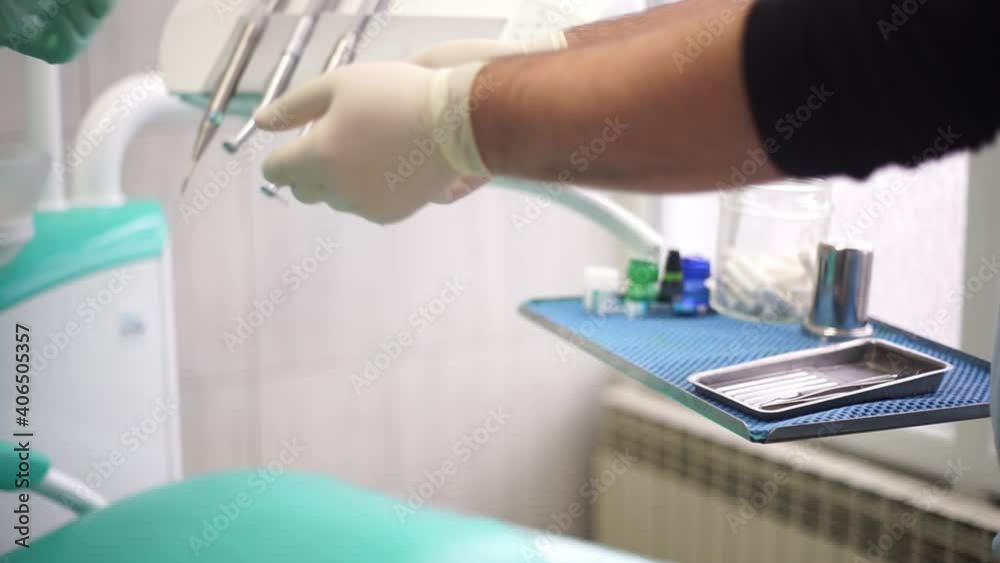 Dental assistant handing of tools from table to dentist Dental assistant handing of tools from table to dentist