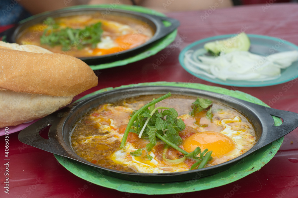Vietnamese street food breakfast: fried eggs dish with a fresh French baguette. Hoi An, Vietnam Vietnamese street food breakfast: fried eggs dish with a fresh French baguette. Hoi An, Vietnam