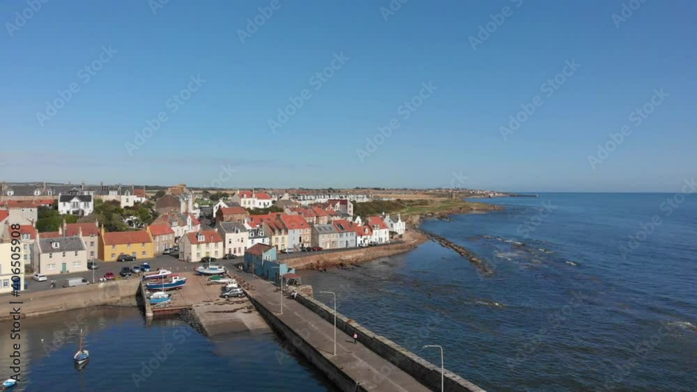 Aerial sweep from st Monance harbour around the coastline with a boat passing by Aerial sweep from st Monance harbour around the coastline with a boat passing by