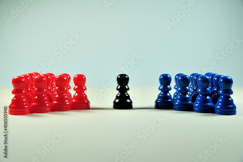 Concept with colored pawns. Neutral mediator between two opposing groups.