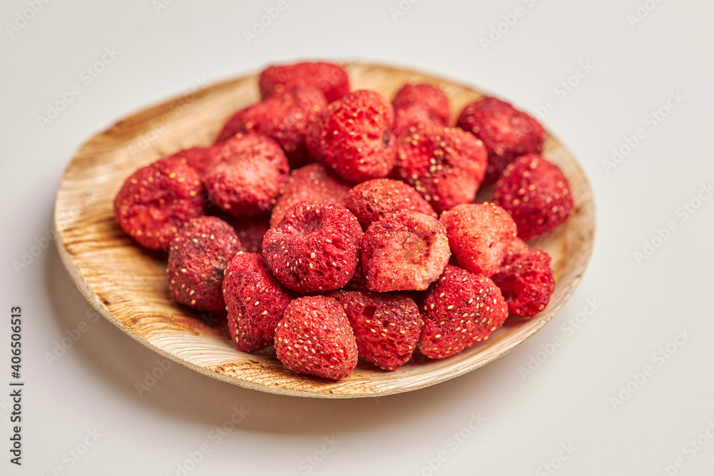 Close-up of dehydrated strawberries in wooden bowl isolated on white background. Close-up of dehydrated strawberries in wooden bowl isolated on white background.