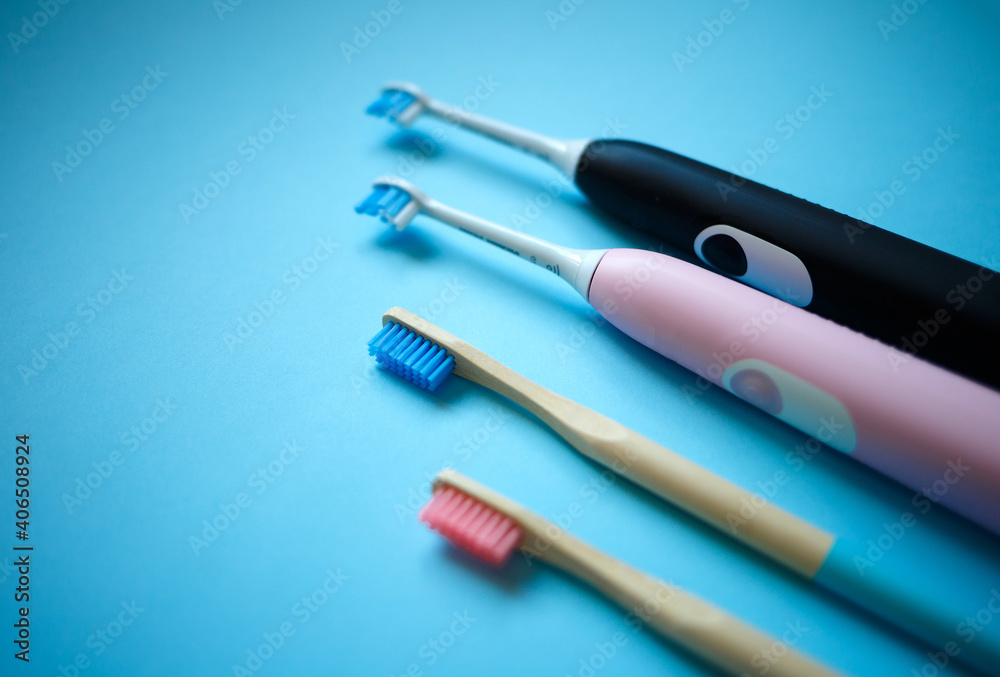 electric and bamboo toothbrushes on a blue background. zero waste electric and bamboo toothbrushes on a blue background. zero waste