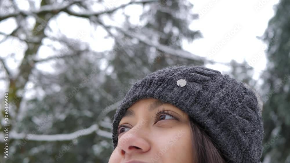 Portrait of young beautiful happy smiling girl wearing knitted beanie hat in the park with trees covered in snow. Winter holidays concept. Portrait of young beautiful happy smiling girl wearing knitted beanie hat in the park with trees covered in snow. Winter holidays concept.