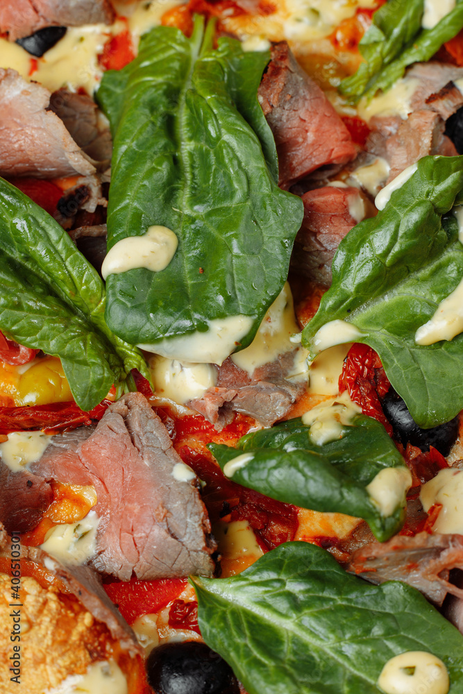Meat Italian pizza with roast beef, steak slices, melted cheese, with olive slices and cheddar cheese. Close up, macro. Pizza time concept Meat Italian pizza with roast beef, steak slices, melted cheese, with olive slices and cheddar cheese. Close up, macro. Pizza time concept