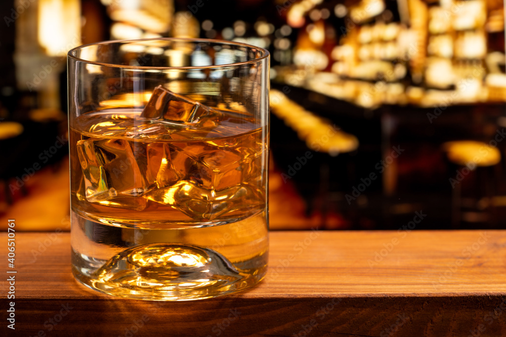 Glass of whiskey with ice cubes at a night club Glass of whiskey with ice cubes at a night club