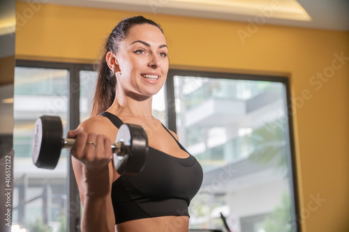 A beautiful athletic young brunette woman in sportswear in the gym. Healthy lifestyle.