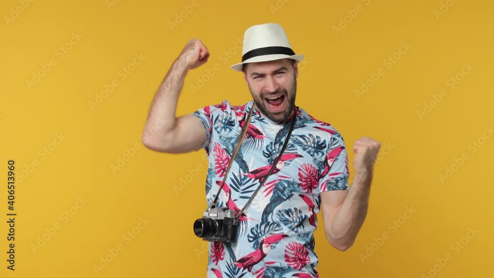 Side profile view traveler tourist man in summer clothes hat isolated on yellow background. Passenger travel on weekends. Air flight journey concept. Turn around camera doing winner gesture screaming Side profile view traveler tourist man in summer clothes hat isolated on yellow background. Passenger travel on weekends. Air flight journey concept. Turn around camera doing winner gesture screaming