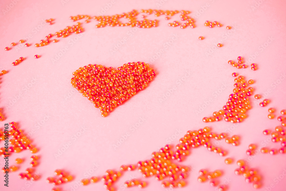 Composition of the heart as a symbol of love laid out from red beads on pink background for valentine's day. Composition of the heart as a symbol of love laid out from red beads on pink background for valentine's day.