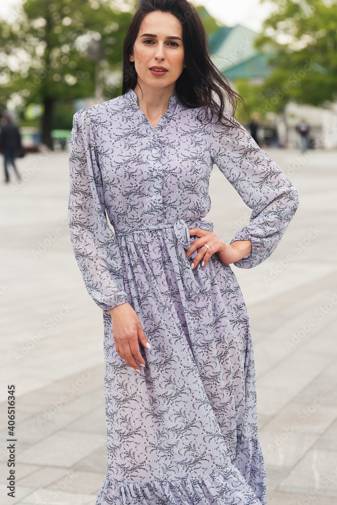 Young elegant girl posing at city street. Pretty beautiful business woman in elegant dress against city background. Young elegant girl posing at city street. Pretty beautiful business woman in elegant dress against city background.