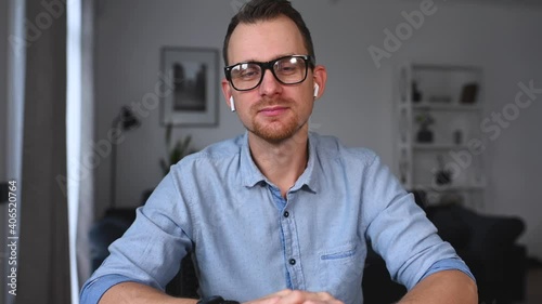 Video meeting with a young man in smart casual outfit, a guy is listening, nods head and agreeing. Virtual conference with an intelligent guy, webcam view
