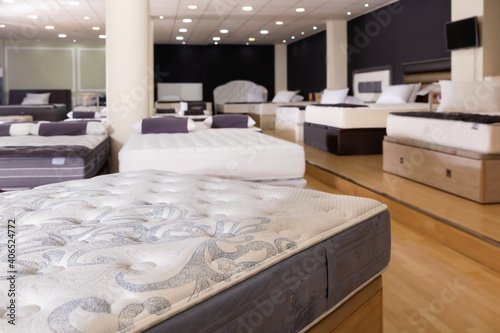 Closeup of new fashionable beautiful stylish orthopaedic mattress on display for sale in large furniture store photo