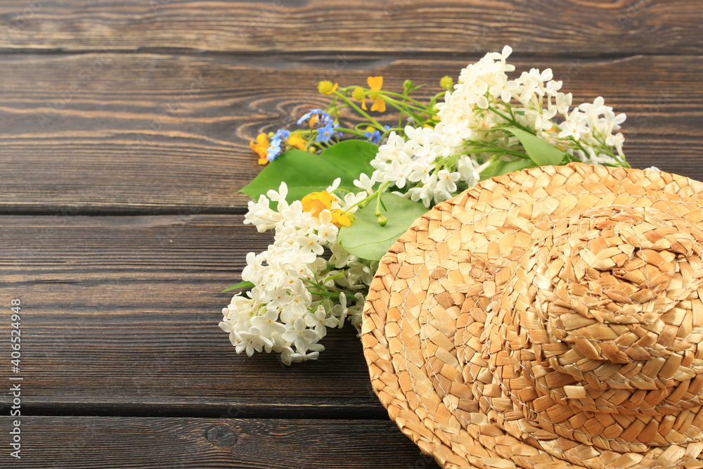 bouquet of spring flowers in a straw hat on a wooden background bouquet of spring flowers in a straw hat on a wooden background