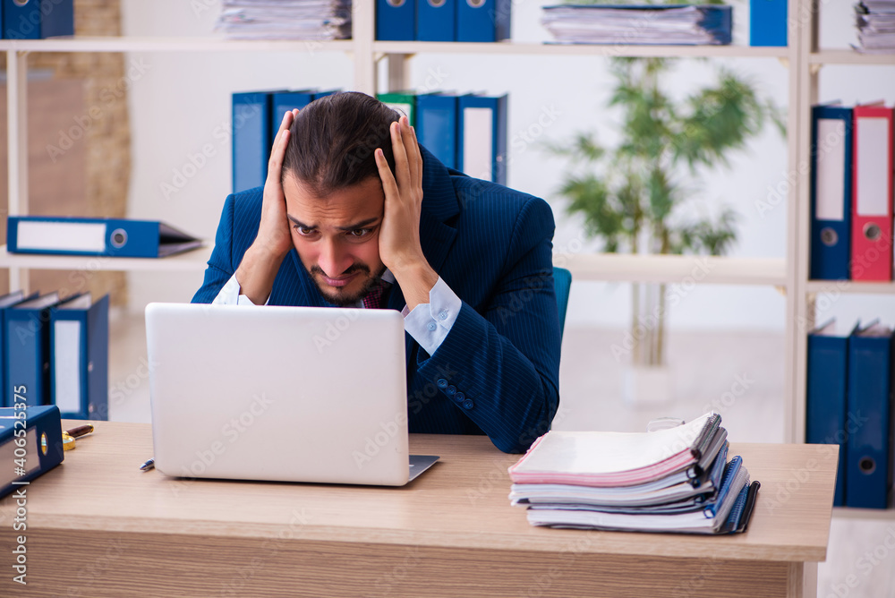 Young male employee and too many work in the office Young male employee and too many work in the office