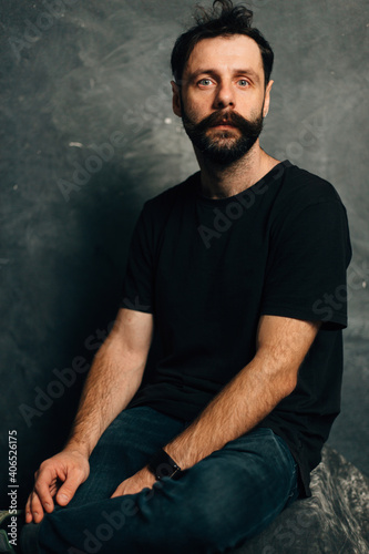 Portrait of a courageous guy with a beard and mustache on a canvas background © alexbutko_com