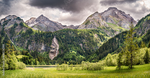 Mountain landscape around the lake Lauenen with the Tungelschuss waterfall on the background, Switzerland