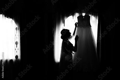 Bride and groom at the window. Silhouette of the bride and groom at the window. Silhouette of newlyweds. Newlyweds at the window. Dance of the newlyweds. The bride and groom waltz. Wedding dance