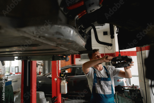Young man repairing car on service station © Svitlana
