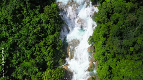 Aerial top view of jungle Waterfall in a tropical forest surrounded by green vegetation. Aliwagwag Falls in mountain jungle. Philippines, Mindanao. photo