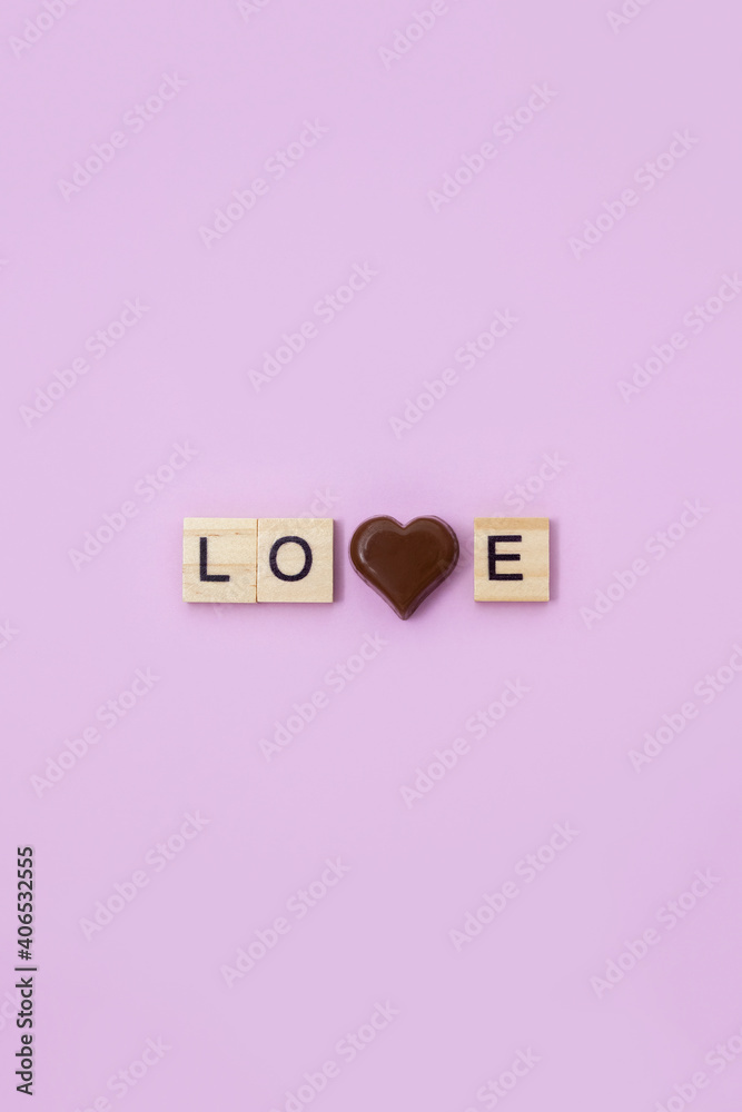 The word love and chocolate heart on light blue background. Valentine's Day postcard. The word love and chocolate heart on light blue background. Valentine's Day postcard.