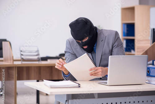 Foto Young male employee in industrial espionage concept