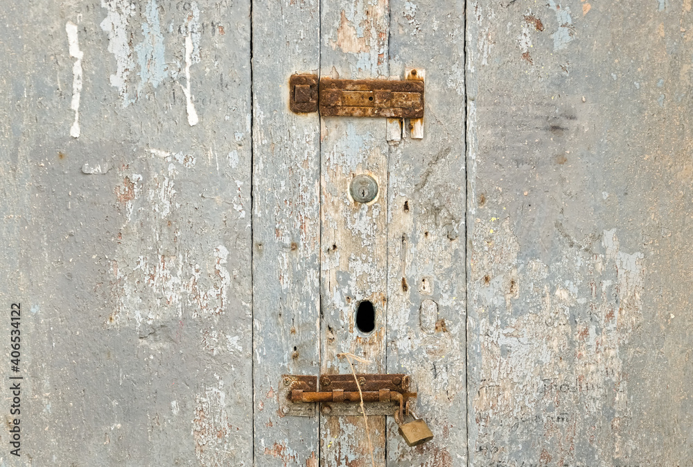 an aged wooden door, with rusty locks that suggests times gone by an aged wooden door, with rusty locks that suggests times gone by