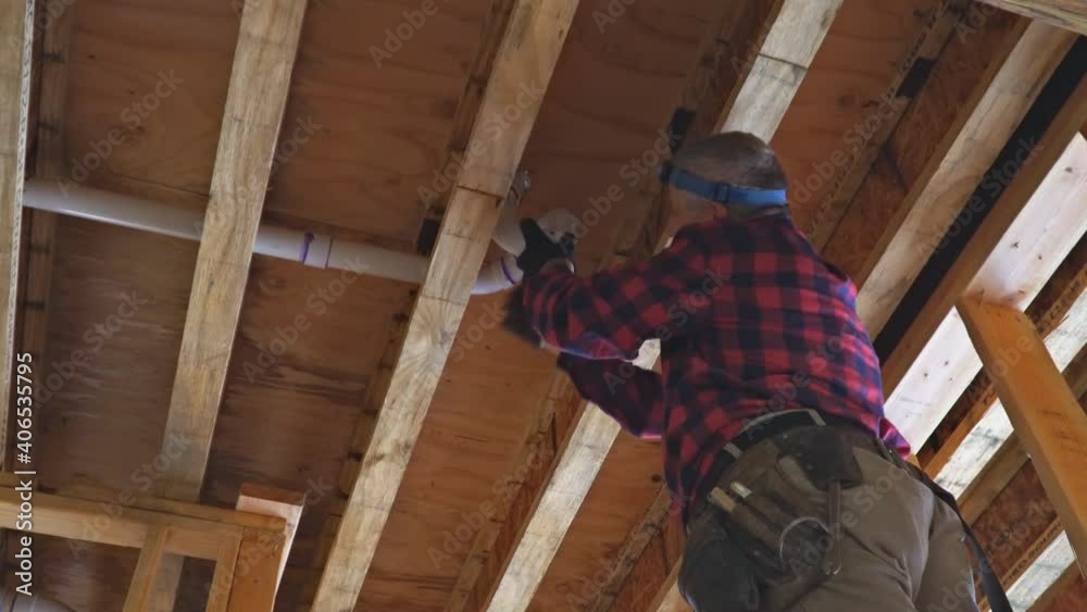 Worker is using glue with fitting for installing the PVC drain pipe in the work area.