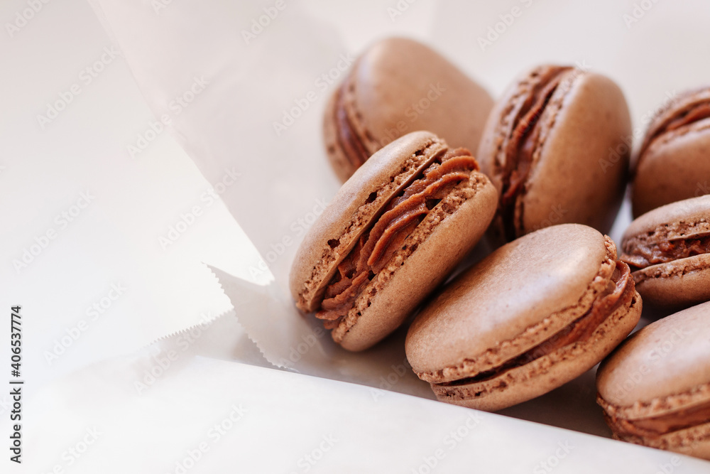 Chocolate macarons served on parchment paper and white plate Chocolate macarons served on parchment paper and white plate