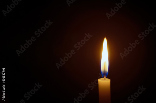 White candle flame closes upon a black background, Candle Burning in the Dark with lights glow, The burning candle's flame with light glow background a symbol of the Christian faith.